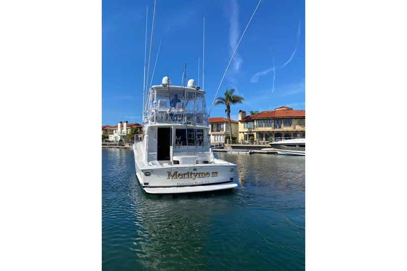 Slide: The Image of 1995 Hatteras 50 Convertible Sportfish yacht docked in a sunny marina setting. - 3