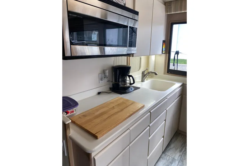 Slide: The Image of Compact kitchen in 1995 Hatteras 50 Convertible Sportfish with microwave, sink, and cutting board. - 51