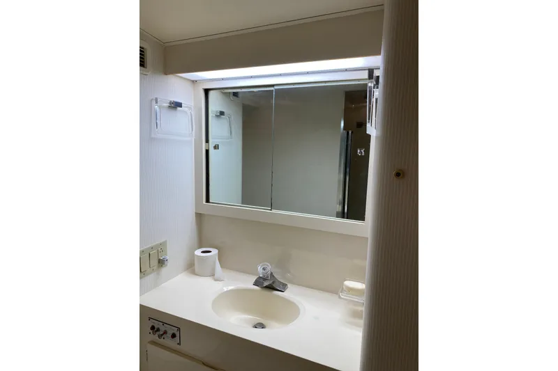 Slide: The Image of Bathroom vanity in 1995 Hatteras 50 Convertible Sportfish yacht, featuring sink and mirror. - 58