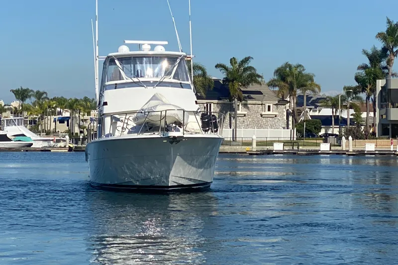 Slide: The Image of 1995 Hatteras 50 Convertible Sportfish yacht cruising in a marina with palm trees. - 7
