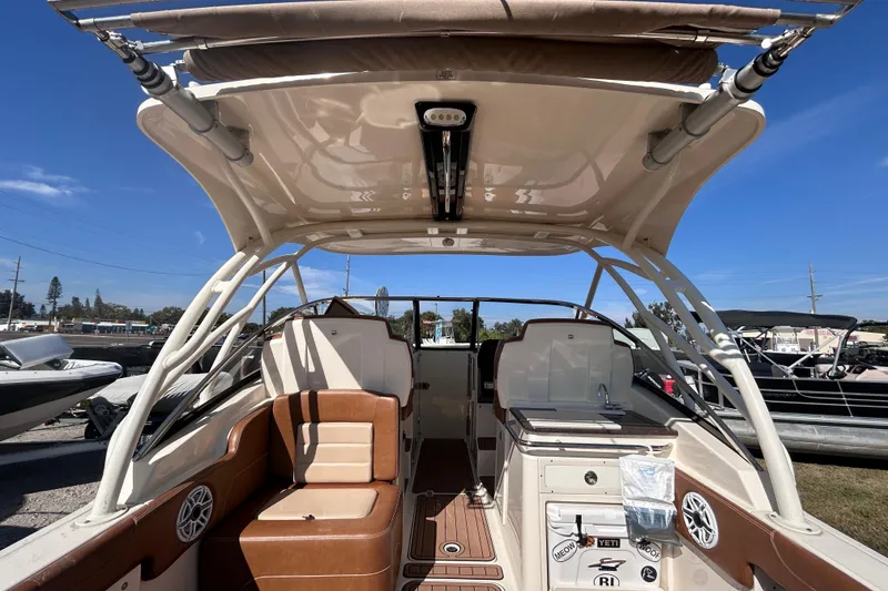 Slide: The Image of 2020 Scout 255 Dorado boat interior with seating and canopy under clear blue sky. - 7