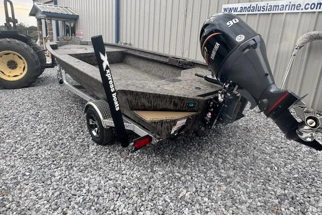 Slide: The Image of 2026 Xpress X18DB boat with 90HP engine on gravel lot near marine shop. - 13