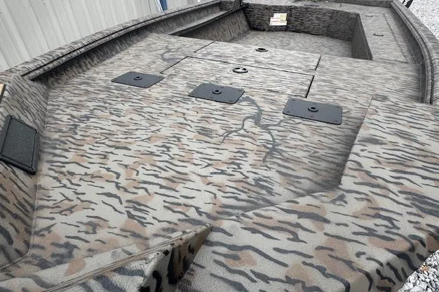 Slide: The Image of Camouflage-patterned deck of 2026 Xpress X18DB boat with storage compartments. - 2