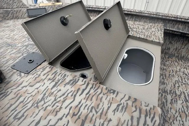 Slide: The Image of 2026 Xpress X18DB boat with open storage compartments on camo-patterned deck. - 3