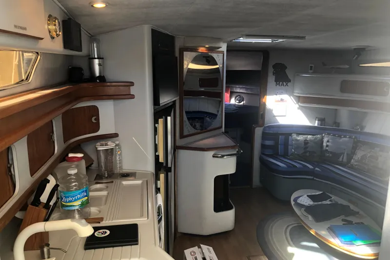Slide: The Image of Interior of 1990 Sea Ray 440 Express yacht with kitchen and seating area. - 10