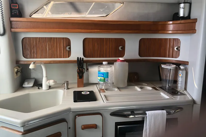 Slide: The Image of Interior kitchen of 1990 Sea Ray 440 Express yacht with wooden cabinets and modern appliances. - 12