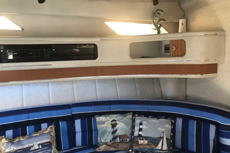 Slide: The Image of Interior of 1990 Sea Ray 440 Express with nautical-themed cushions and built-in stereo system. - 15