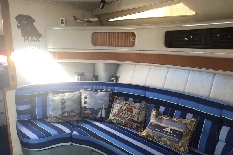 Slide: The Image of Interior of 1990 Sea Ray 440 Express with striped seating and nautical-themed pillows. - 16
