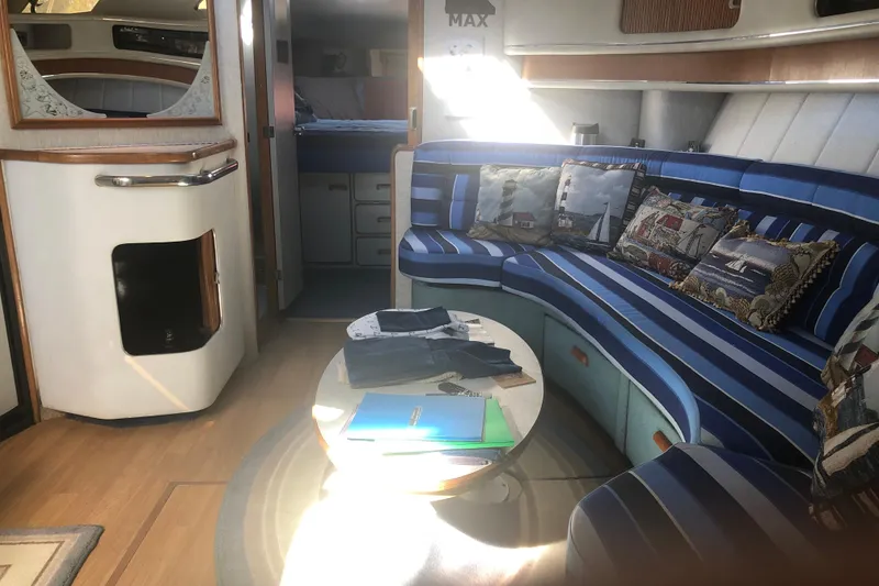 Slide: The Image of Interior of 1990 Sea Ray 440 Express with striped seating and nautical-themed pillows. - 18