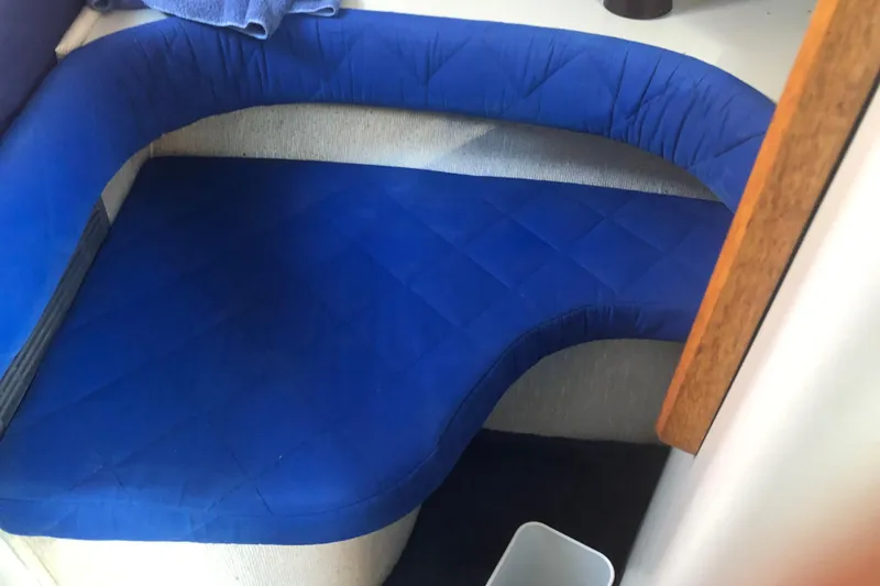 Slide: The Image of Interior seating of 1990 Sea Ray 440 Express with blue upholstery. - 25