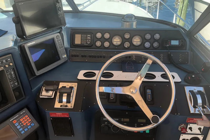 Slide: The Image of 1990 Sea Ray 440 Express helm with navigation equipment and steering wheel. - 3