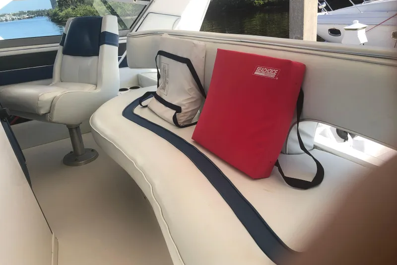 Slide: The Image of Interior of 1990 Sea Ray 440 Express with white seating and red cushion. - 5