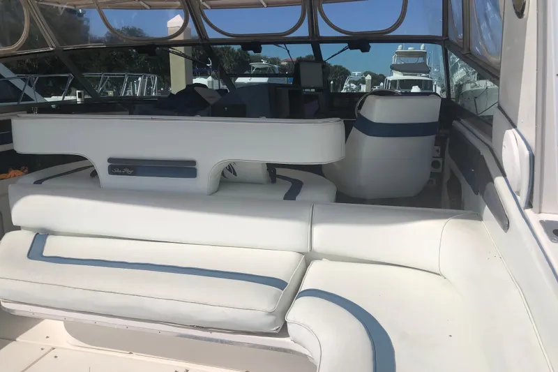 Slide: The Image of Interior of a 1990 Sea Ray 440 Express boat with white and blue seating. - 9