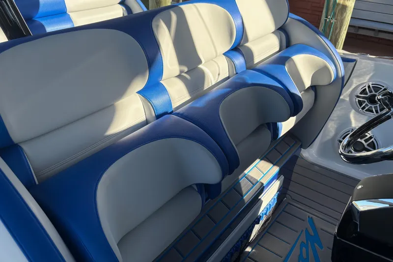Slide: The Image of 2023 Nor-Tech 390 Sport Center Console with blue and gray seating and steering wheel. - 13