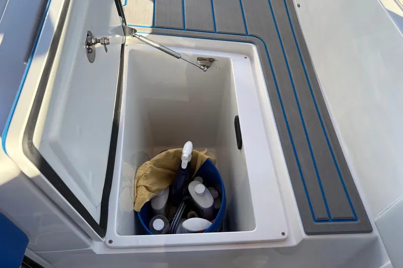 Slide: The Image of 2023 Nor-Tech 390 Sport Center Console storage compartment with cleaning supplies. - 26