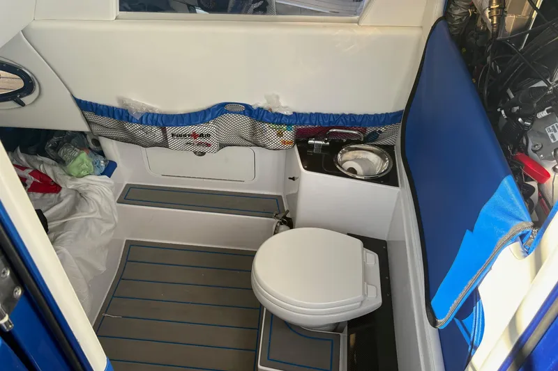 Slide: The Image of 2023 Nor-Tech 390 Sport Center Console interior with compact marine toilet and sink. - 27