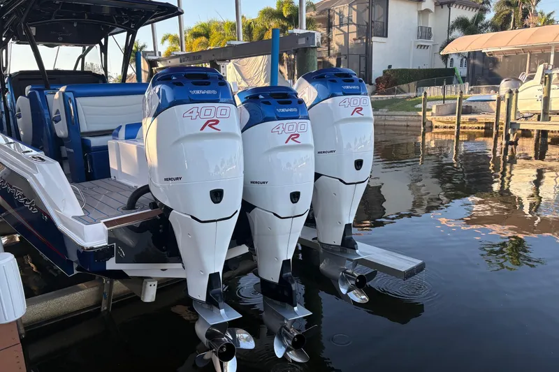 Slide: The Image of 2023 Nor-Tech 390 Sport Center Console with triple Mercury 400R engines docked by waterfront. - 29