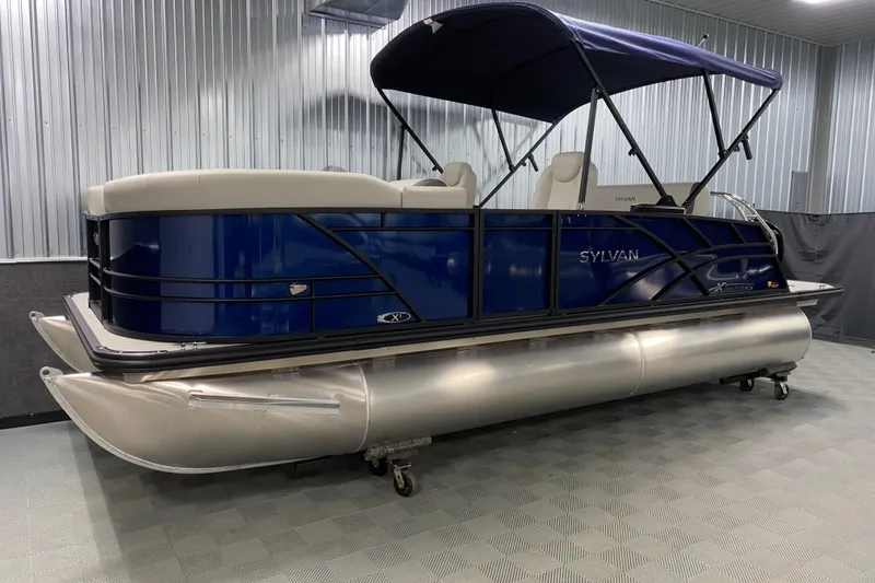 The Image of 2026 Sylvan Mirage 8520 CLZ DH pontoon boat with blue exterior and canopy in showroom. - 0