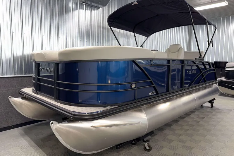 Slide: The Image of 2026 Sylvan Mirage 8520 CLZ DH pontoon boat in showroom, featuring sleek blue design. - 18