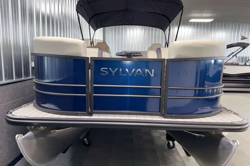 Slide: The Image of 2026 Sylvan Mirage 8520 CLZ DH pontoon boat in showroom, featuring sleek blue design. - 19