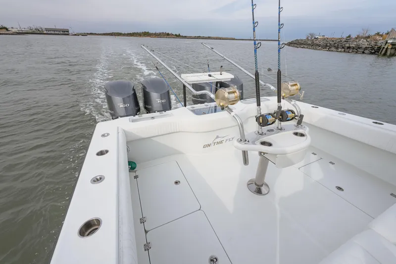 Slide: The Image of Freeman 37 VH 2018 boat with fishing rods and dual engines on open water. - 12