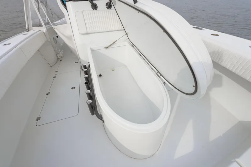 Slide: The Image of 2018 Freeman 37 VH boat deck with open storage compartment, white interior, and rod holders. - 15