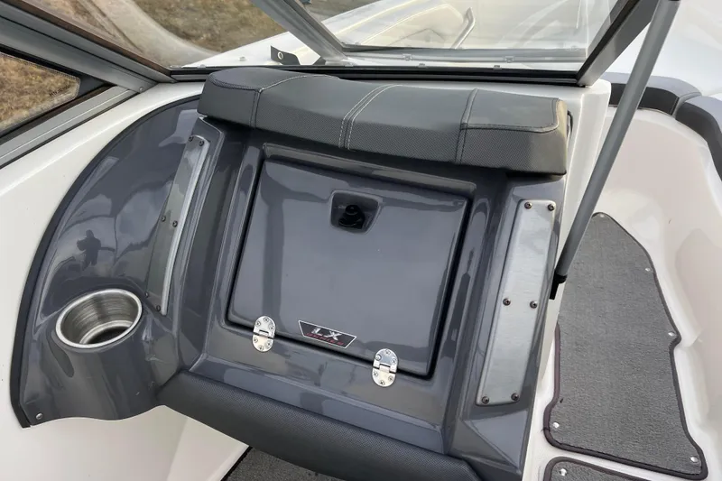 Slide: The Image of 2013 Larson LX 205S IO boat interior with cup holder and storage compartment. - 21