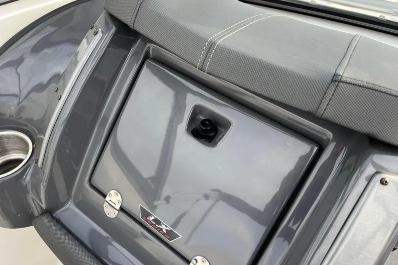 Slide: The Image of 2013 Larson LX 205S IO boat interior detail with cup holder and storage compartment. - 22