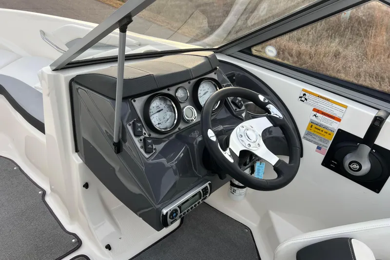 Slide: The Image of 2013 Larson LX 205S IO boat dashboard with steering wheel and gauges. - 24