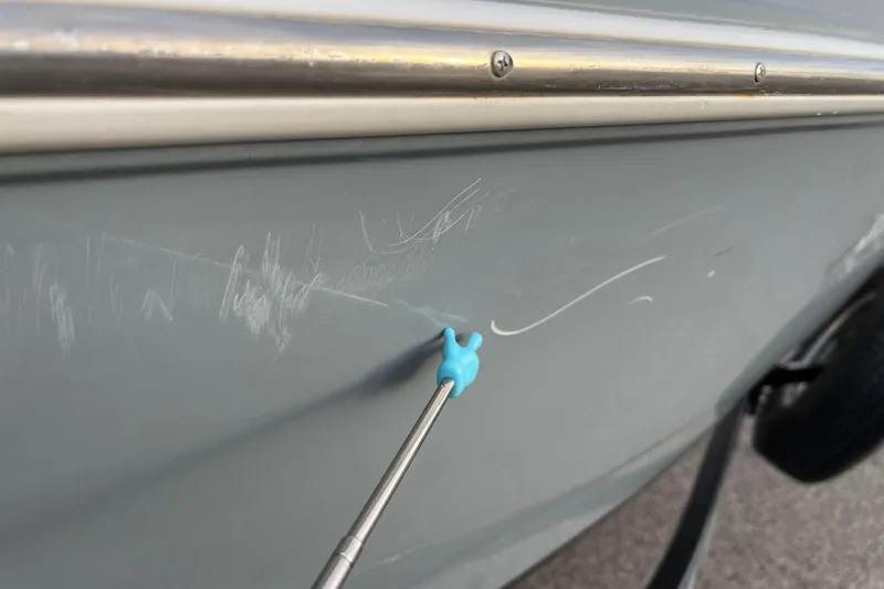 Slide: The Image of 2013 Larson LX 205S IO boat with visible scratches on the hull. - 43