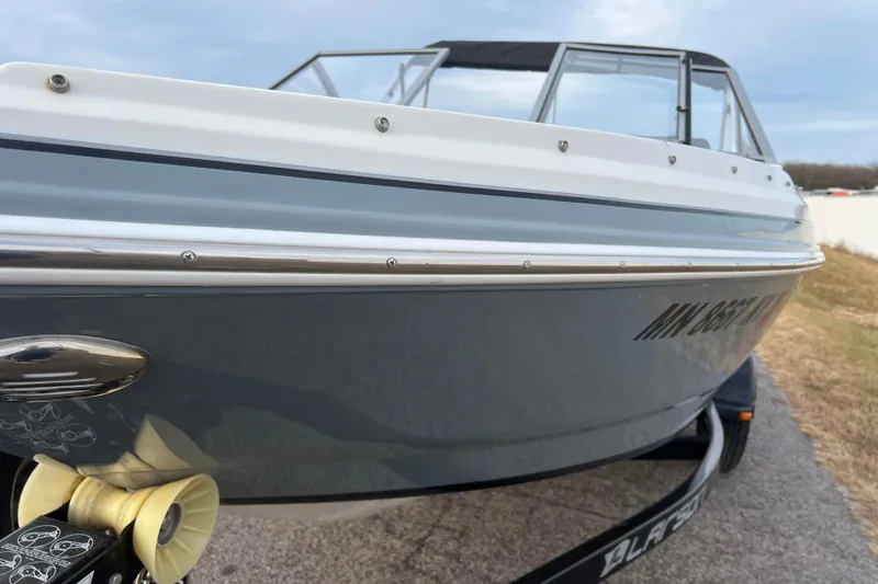 Slide: The Image of 2013 Larson LX 205S IO boat on trailer, side view with registration number visible. - 47