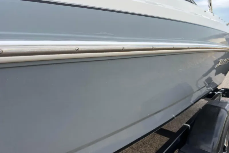 Slide: The Image of 2013 Larson LX 205S IO boat side view with sleek design and metallic trim. - 52