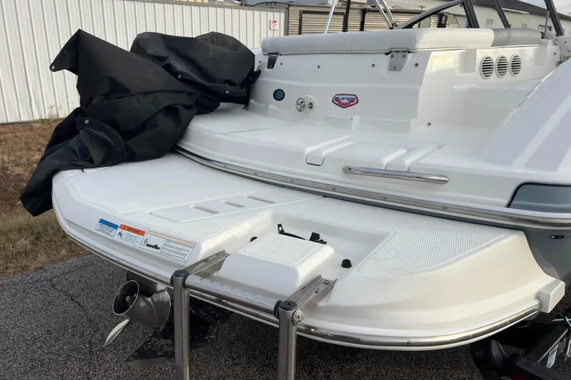 Slide: The Image of 2013 Larson LX 205S IO boat rear view with swim platform and ladder. - 55