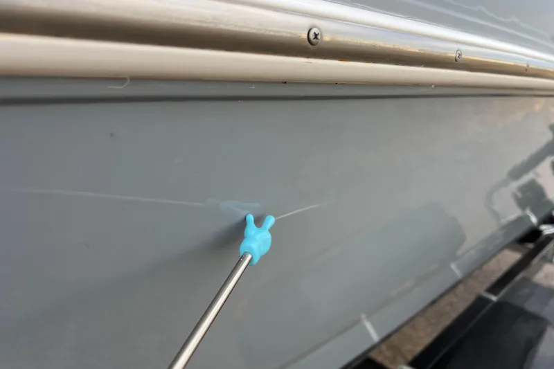 Slide: The Image of Close-up of a 2013 Larson LX 205S IO boat hull with a small scratch. - 59