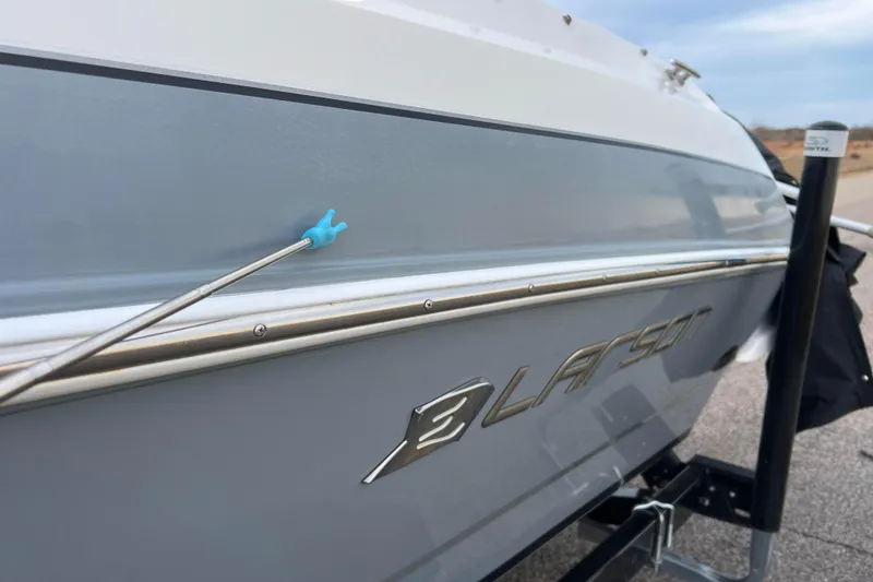 Slide: The Image of 2013 Larson LX 205S IO boat side view with logo and blue detail. - 61