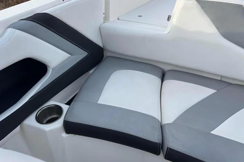 Slide: The Image of 2013 Larson LX 205S IO boat interior with gray and white seating and cup holder. - 7
