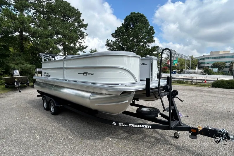Slide: The Image of 2026 Sun Tracker Party Barge 20 Classic Series pontoon boat on trailer, parked outdoors. - 5
