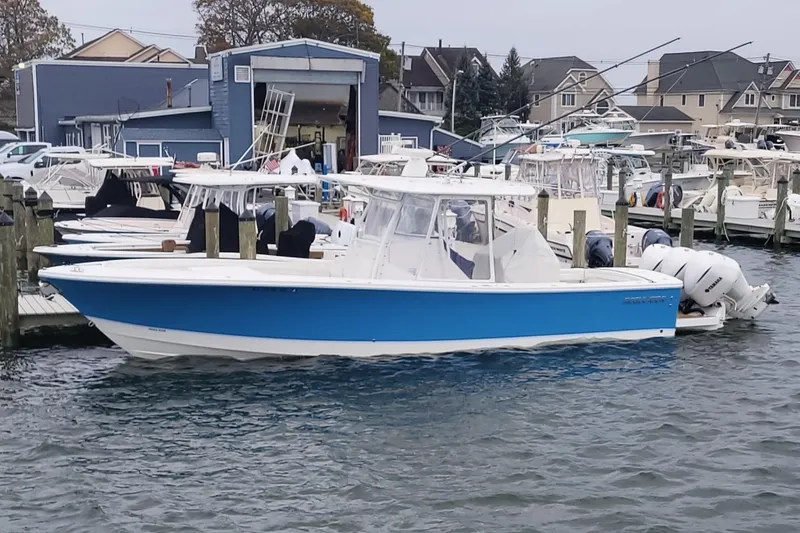 The Image of 2019 Regulator 34SS boat docked at a marina, featuring a sleek blue and white design. - 0