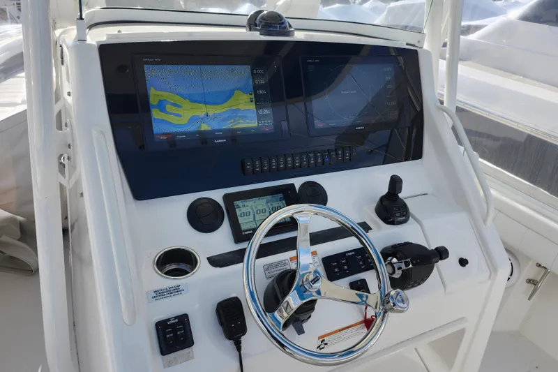Slide: The Image of Control panel of 2019 Regulator 34SS boat with navigation screens and steering wheel. - 13