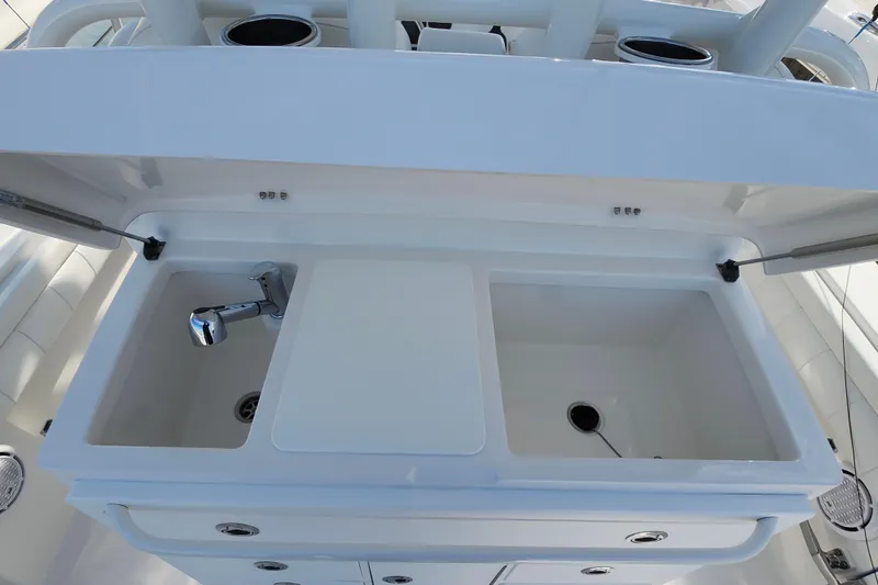 Slide: The Image of 2019 Regulator 34SS boat sink and storage area with dual compartments. - 20