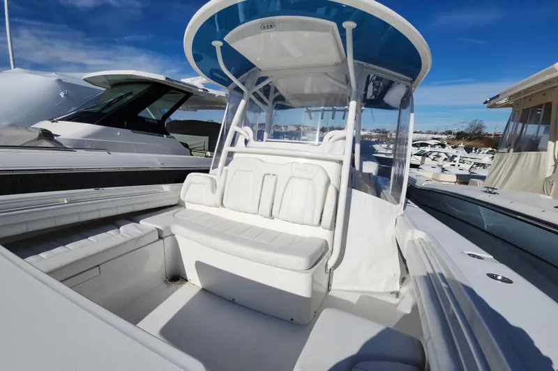 Slide: The Image of 2019 Regulator 34SS boat with white seating and canopy, docked under a clear blue sky. - 27