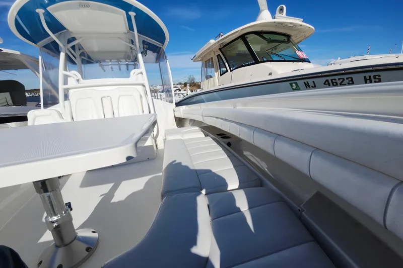 Slide: The Image of 2019 Regulator 34SS boat interior with seating and table, docked beside another vessel. - 29