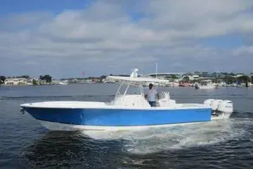 Slide: The Image of 2019 Regulator 34SS boat cruising on a calm waterway under a partly cloudy sky. - 3