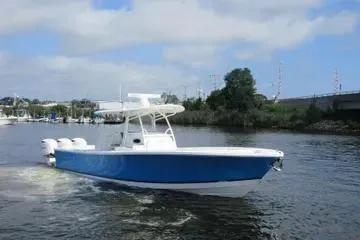 Slide: The Image of 2019 Regulator 34SS boat cruising on a calm river under a partly cloudy sky. - 4