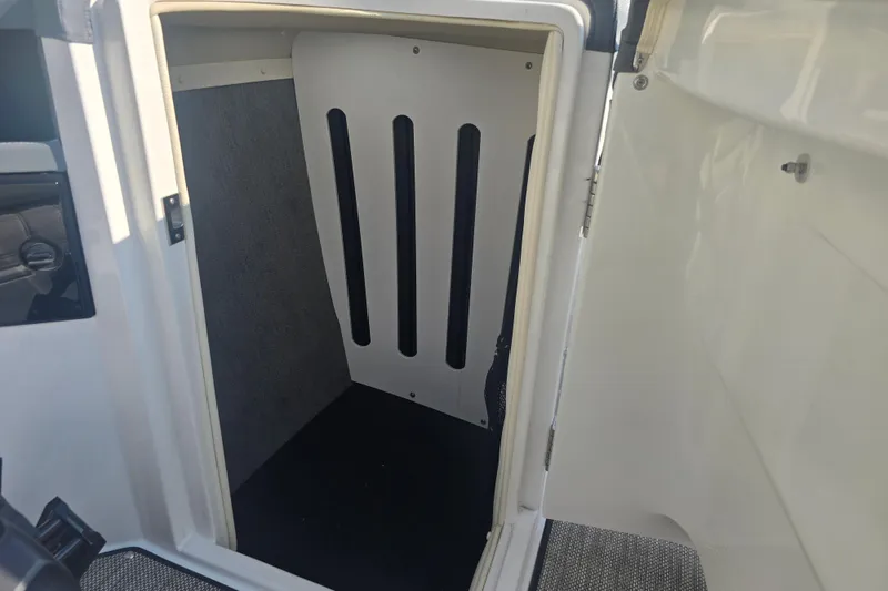 Slide: The Image of 2019 Cobalt R5 Surf boat interior storage compartment with open door. - 27