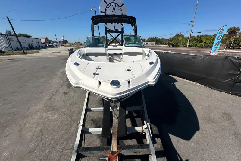 Slide: The Image of 2015 Chaparral 246 boat on trailer, displayed outdoors under clear blue sky. - 1