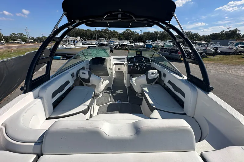Slide: The Image of 2015 Chaparral 246 boat interior with seating and steering wheel, parked outdoors. - 10