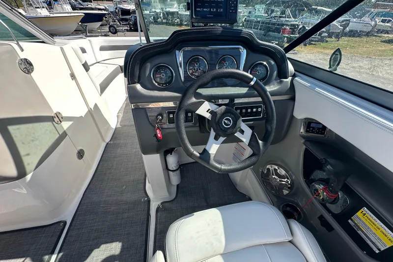 Slide: The Image of 2015 Chaparral 246 boat cockpit with steering wheel and dashboard controls. - 12