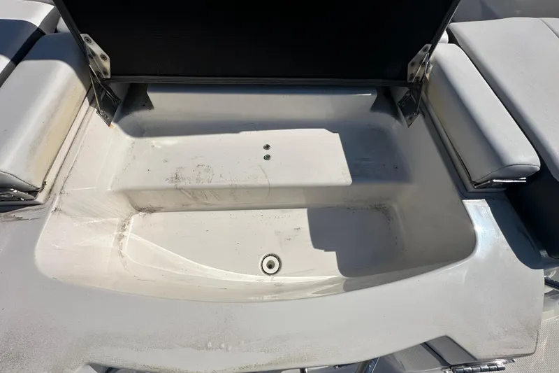Slide: The Image of Open storage compartment on a 2015 Chaparral 246 boat, showing interior details. - 27