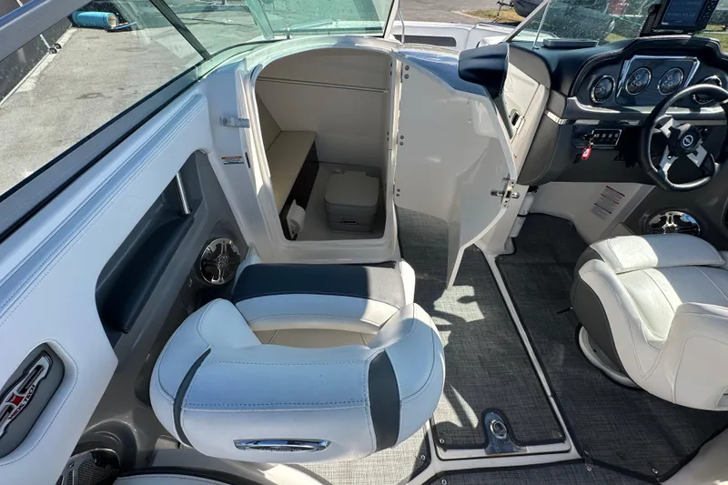 Slide: The Image of 2015 Chaparral 246 boat interior with seating, steering wheel, and cabin entrance. - 37